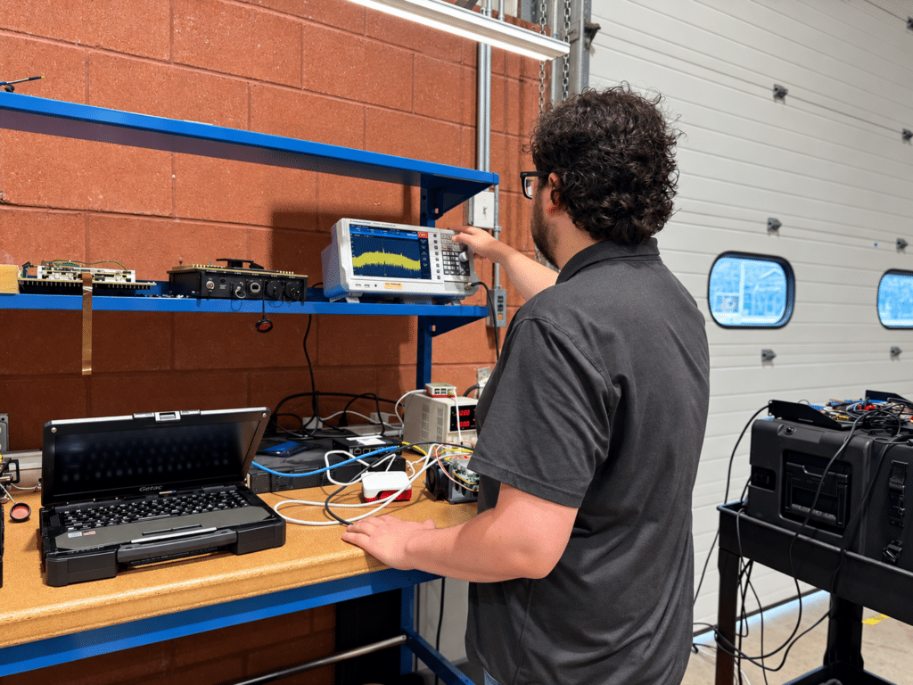 Spectrum analyzer displaying test data during electrical engineering work at Lite Coms.